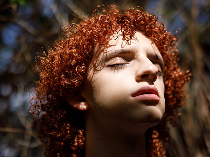A person with red, curly hair looking anxious