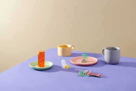 Cups and saucers on a table with different pills on them representing Fosamax alternatives