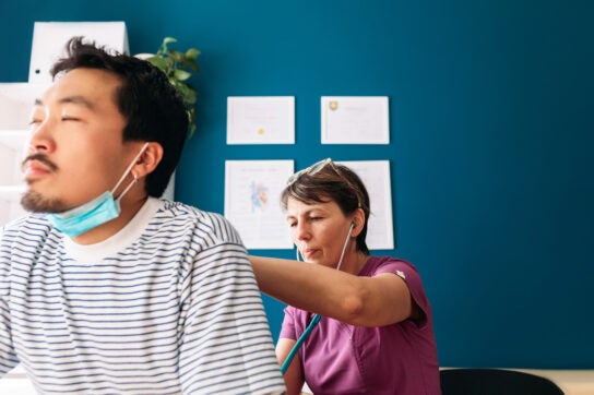 Female doctor listening to patient's lungs