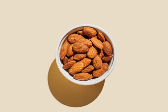 Overhead view of raw whole almonds in small bowl